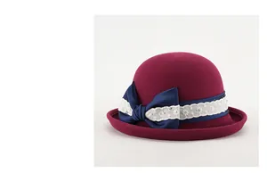Dettaglio cappello cloche in lana con nastro blu scuro e bordo in pizzo floreale bianco