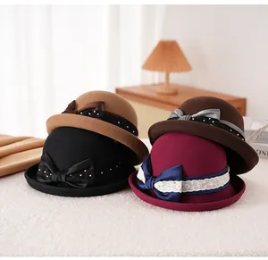 Dettaglio di cappelli in lana con fiocchi di raso, perle e pizzo in quattro colori eleganti