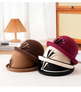 Λεπτομέρεια από μάλλινα καπέλα cloche με πέρλες σε απαλό λευκό ανάγλυφο χαλί