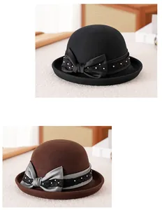 Dettaglio del cappello cloche in feltro di lana con fiocco in raso e perle decorative