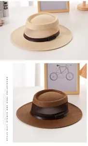 Dettaglio di cappelli di paglia a tesa larga con cinturini in pelle e incisioni del marchio
