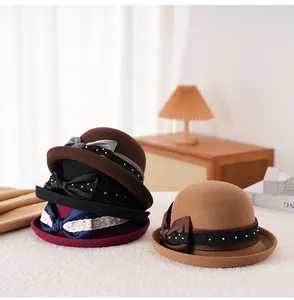 Dettagli di cappelli cloche in lana in vari colori con fiocco di raso e pizzo