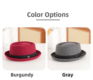 Detail view of wine red and grey wool felt hats with black ribbons and metal emblems