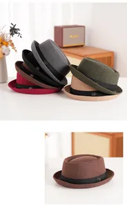 Detail of wool pork pie hat featuring grosgrain ribbon and a gold metallic brand logo