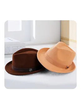 Detail view of wool felt jazz hats in dark brown and light camel with metal logo