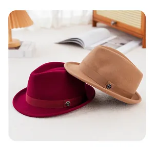 Close-up of wool fedora hats in burgundy and camel with decorative metal hexagon logo
