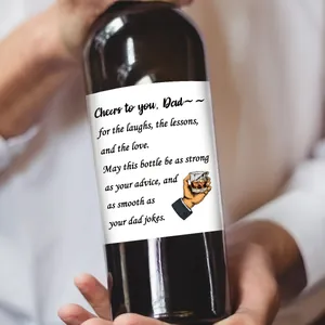 Détail d'une main tenant une bouteille de vin avec étiquette cadeau fête des pères
