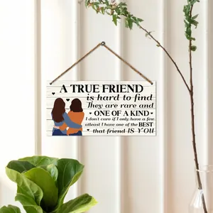 Detail of wooden wall plaque with friendship illustration and quote on textured wall
