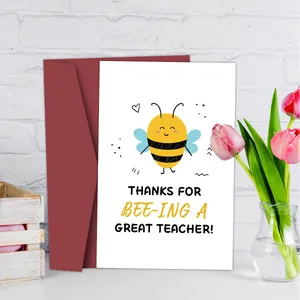 Detalle de una tarjeta de agradecimiento para profesores con abeja y sobre color burdeos