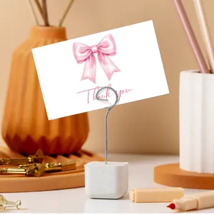 Stone base metal clip holder with watercolor bow thank you card on a cozy desk