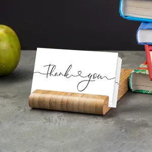 Detail of bamboo business card holder with thank you cards on a desk