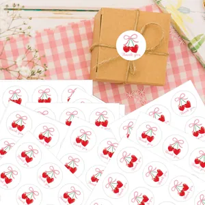 Detail of round cherry stickers on kraft gift box with Thank You text and twine decoration