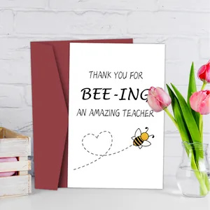 Detalle de tarjeta de agradecimiento para profesores con abeja y sobre rojo oscuro