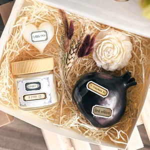 Gros plan d'un coffret cadeau bougie parfumée vintage avec tablette de cire et fleur blanche