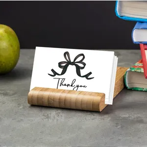 Detail of thank you card with bow illustration on natural wooden card holder stand