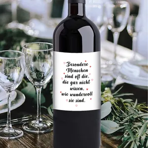 Detail of wine bottle label with German sentimental text and red hearts on a dinner table