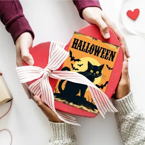 Close-up of red heart gift box with Halloween black cat card and striped ribbon bow