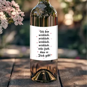 Outdoor setting showing a wine bottle sticker with German text on a wood table