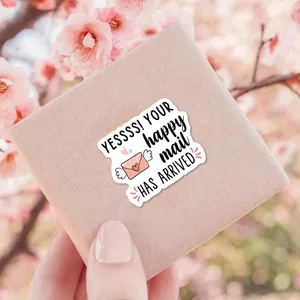 Dettaglio dell'adesivo 'Happy Mail' con busta a cuore rosa su scatola di carta kraft
