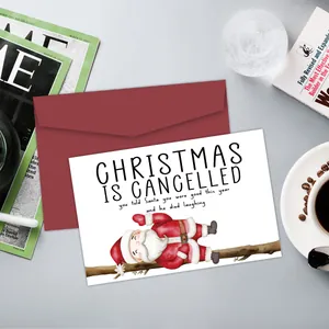 Funny Christmas card with Santa illustration and red envelope on a stylish desk setting