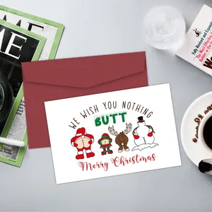 Funny Christmas card with 'NOTTING BUTT' pun next to red envelope on a cozy desk