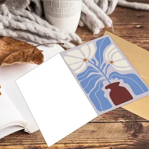 Biglietti d'auguri floreali stile Matisse con buste su una scrivania in legno caldo