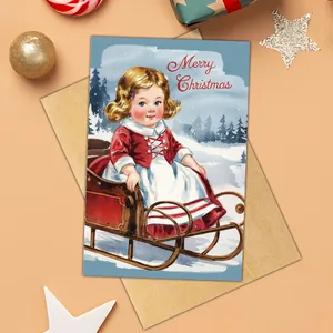 Detail of vintage Christmas card with girl on sled illustration and kraft envelope