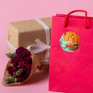 Détail de l'autocollant d'Halloween sur un sac cadeau rouge avec une illustration rétro d'un enfant