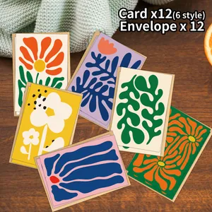 Dettaglio di 12 biglietti vintage stile Matisse con buste marroni su piano di legno