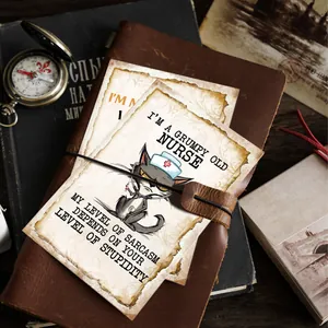 Détail d'une carte d'humour chat infirmière vintage sur un carnet en cuir avec décor