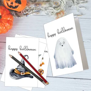 Flat lay of watercolor Halloween cards with ghost and pumpkin motifs on wood background