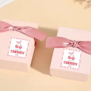 Detail of pink gift boxes with silk bows and cherry-themed Thank You labels