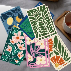 Flat lay of colorful floral greeting cards with envelopes on a textured desk background