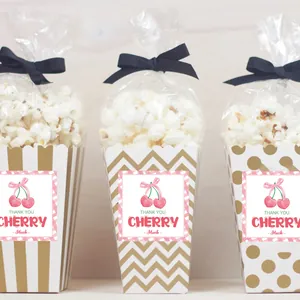Detail of sweet cherry thank you stickers on popcorn gift boxes with golden patterns