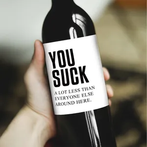 Hand hält lustige Weihnachts-Weinflaschenetiketten mit humorvollem Spruch-Aufkleber