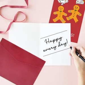 Close-up of festive gingerbread Christmas card set with red envelope and handwriting detail