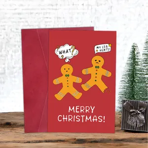 Close-up of red gingerbread man Christmas card and envelope on a wooden table setup