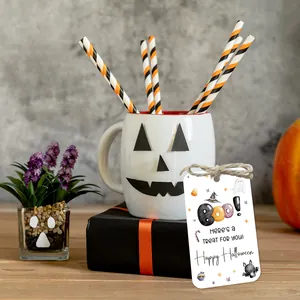 Close-up of Halloween gift tags with ghost icons and twine next to a gift box