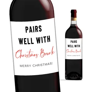 Nahaufnahme lustiger Weihnachts-Weinetiketten mit PAIRS WELL WITH Text auf roter Flasche
