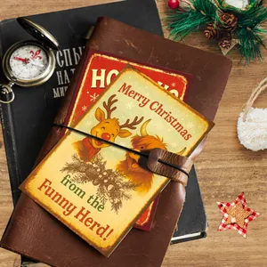 Detail of vintage Christmas postcards with reindeer illustration in a leather journal