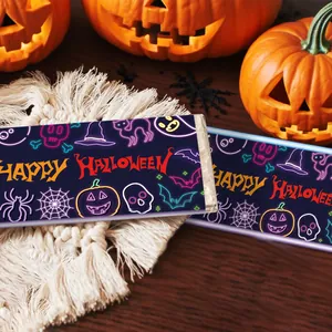 Involucri per cioccolato Halloween neon con ragni e zucche su sfondo di tessuto bianco