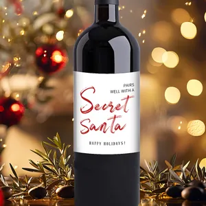 Gros plan d'étiquettes de vin Secret Santa autocollantes sur fond de fête de Noël