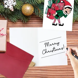 Close-up of handwriting on a Merry Christmas card with festive envelope and gift box