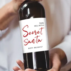 Gros plan d'étiquettes autocollantes Secret Santa pour bouteilles de vin de Noël