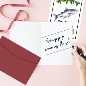 Detail van kerstkaarten met bordeauxrode envelop en handgeschreven stijl vakantiewensen