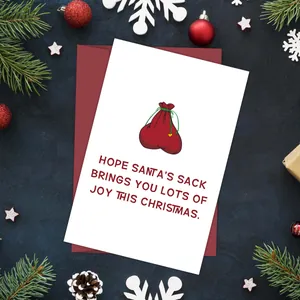 Gevouwen kerstkaart met rode envelop en feestelijke decoraties op een donkere achtergrond