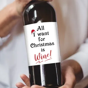 Gros plan de mains tenant une bouteille de vin avec étiquette de Noël et motifs