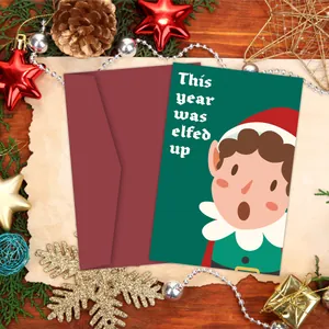 Close-up van een grappige kerstkaart met elf, rode envelop en feestelijke decoratie