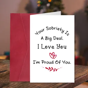 Detail of sobriety card with red envelope on a wooden table with festive lights