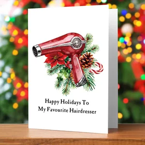 Close-up of a Christmas card for hairdressers on wood with festive bokeh background